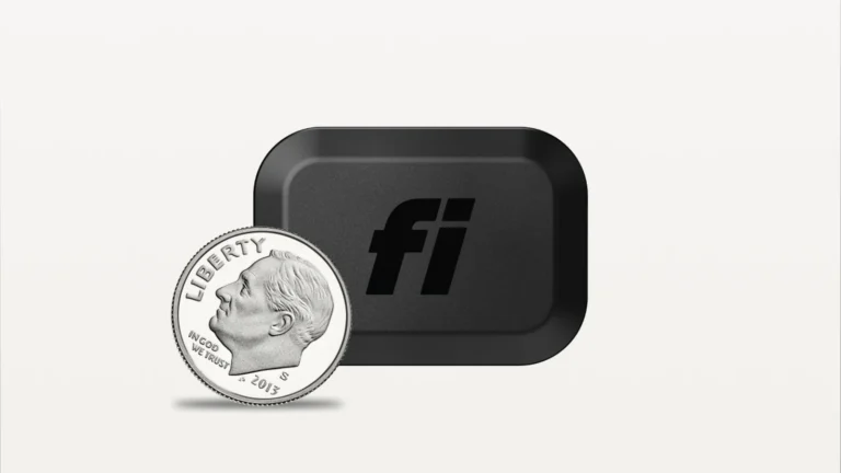 Black Fi Mini tracker beside a US dime, showing the tracker is only slightly wider than the coin
