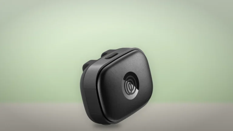 The black Life360 Pet GPS tracker seen from the front at an angle, with its top button and logo window
