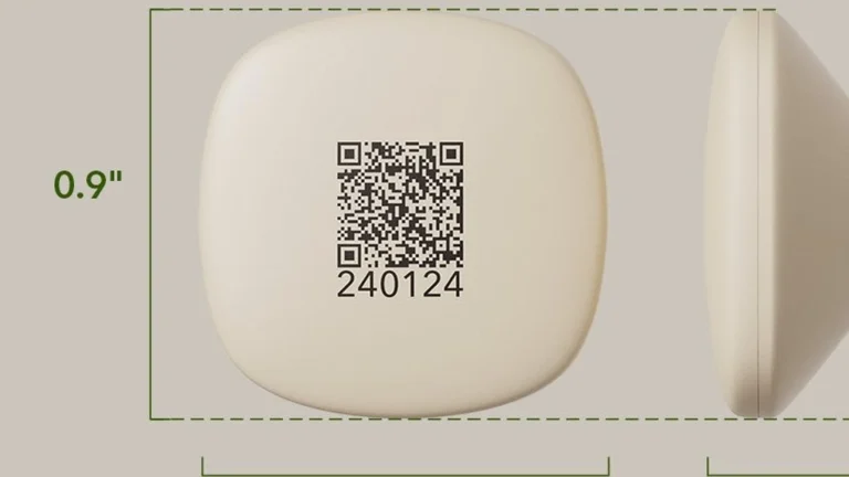 The beige PETLIBRO RFID collar tag from the front with its QR code, and in profile, with a 0.9 inch dimension line